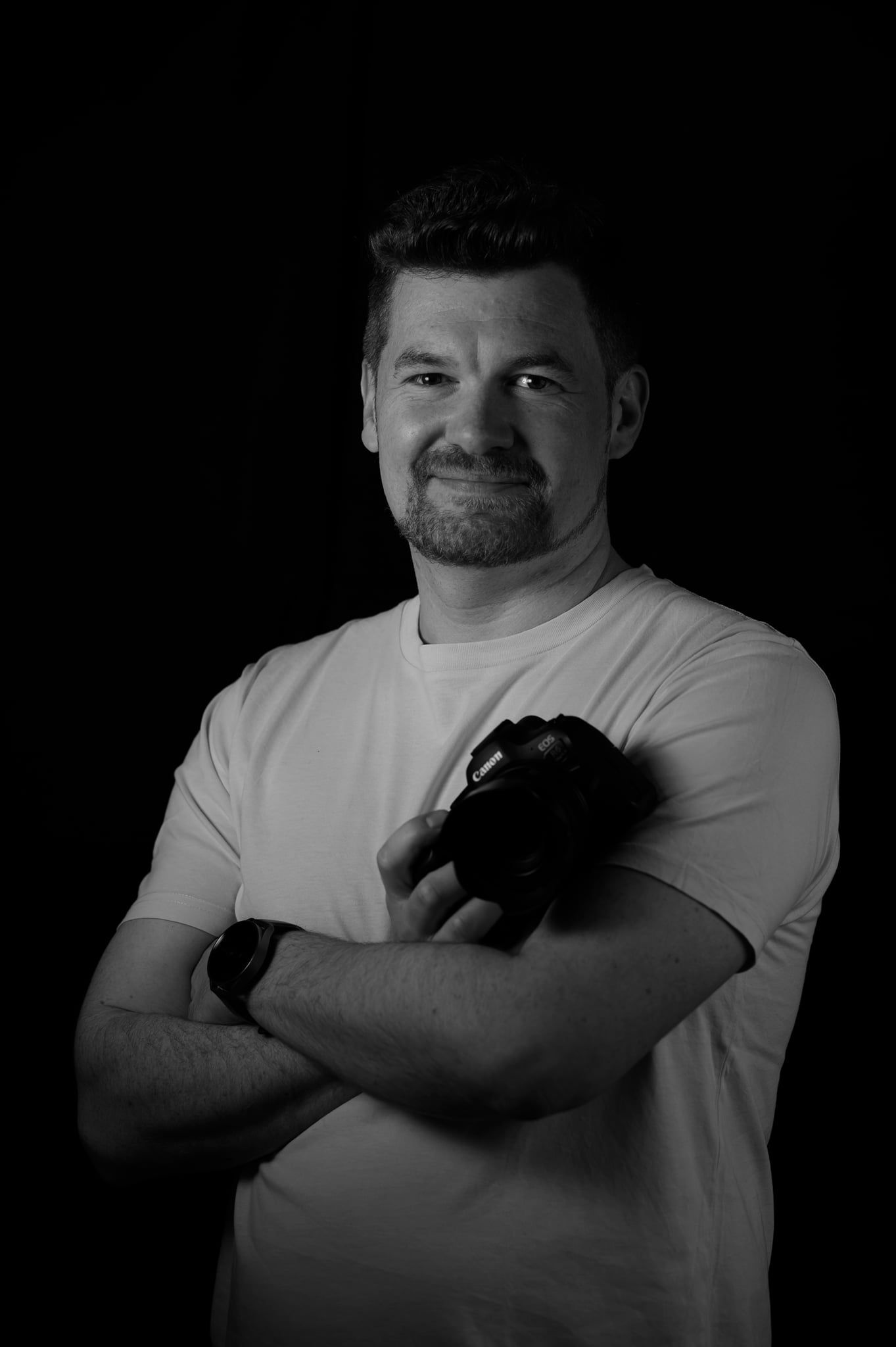 Daniel mit verschränkten Armen und Kamera vor der Brust