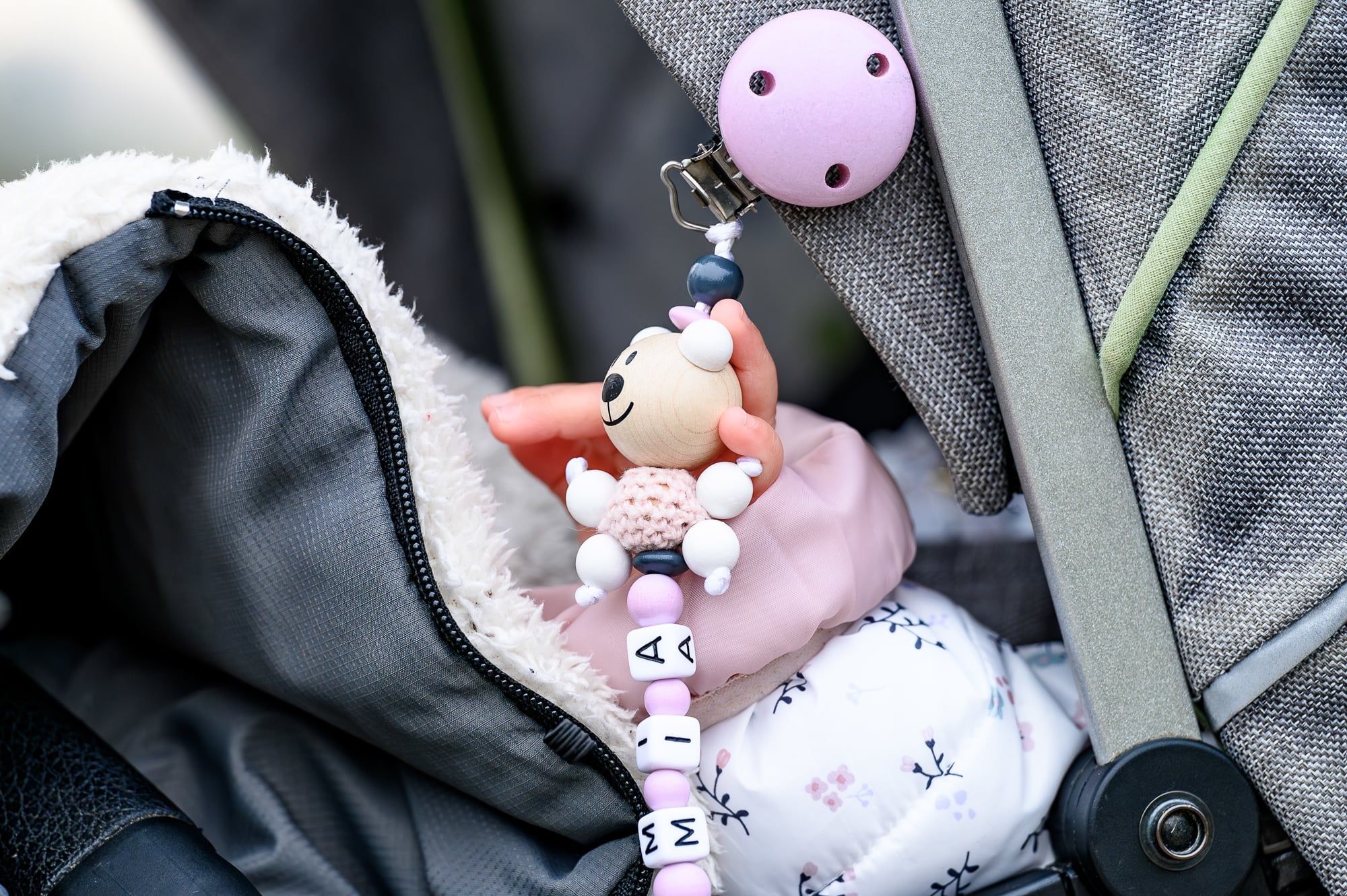 Baby schläft im Kinderwagen, daneben eine bunte Schnullerkette – Familienshooting in Augsburg