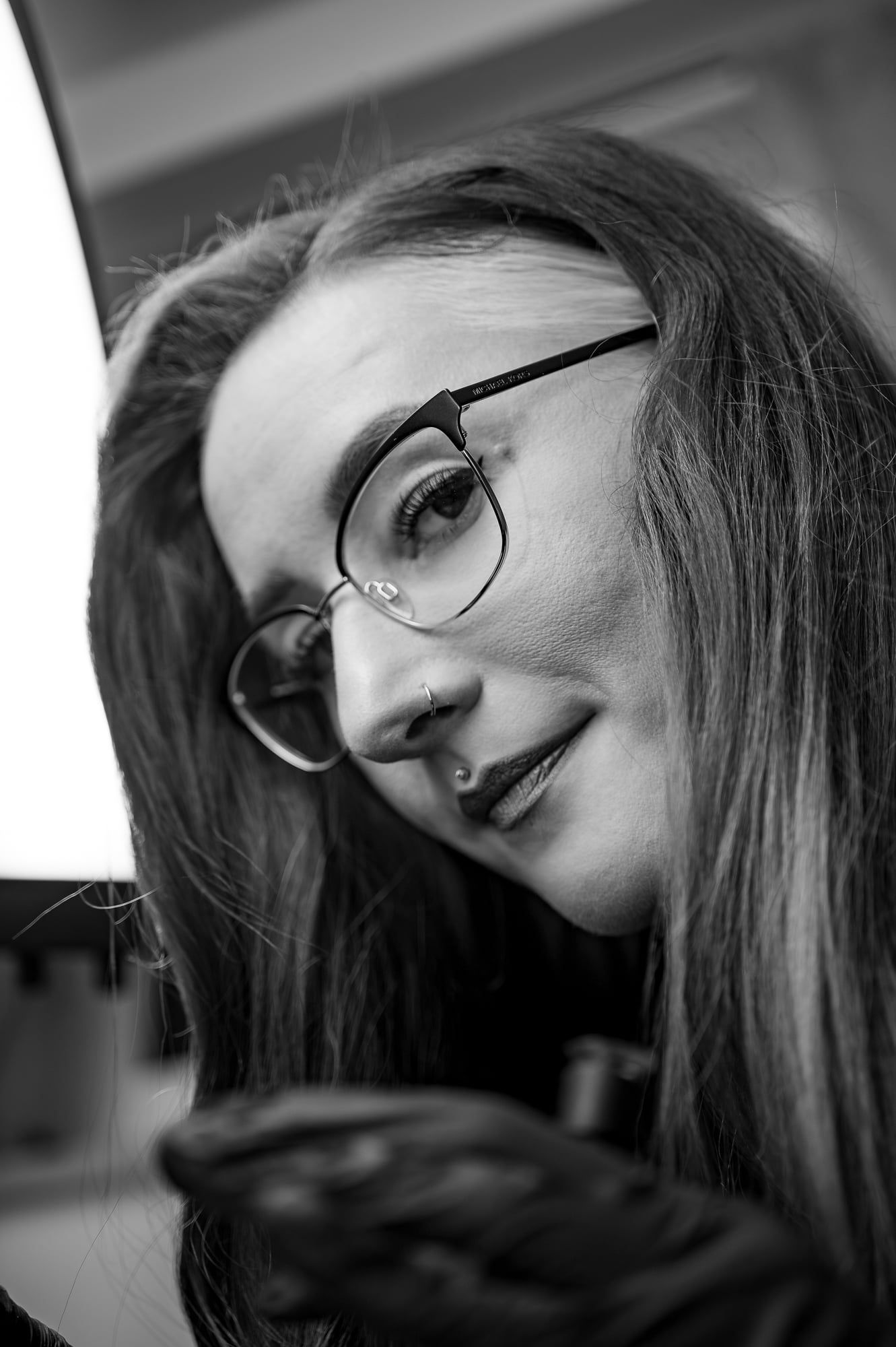 Schwarzweißes Portrait einer Frau mit Brille und langen Haaren, den Kopf leicht geneigt – Portrait in Augsburg
