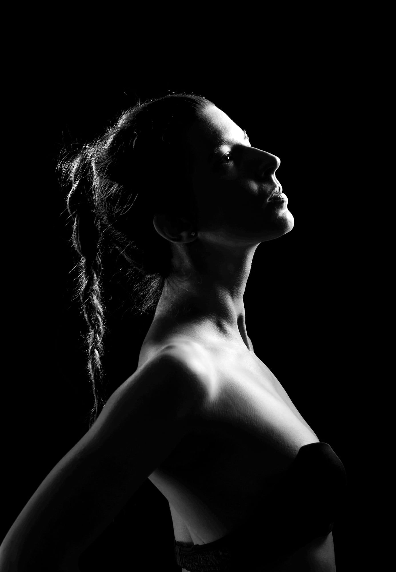 Schwarzweißes Low-Key-Portrait einer Frau im Profil mit nackten Schultern – Portrait in Augsburg