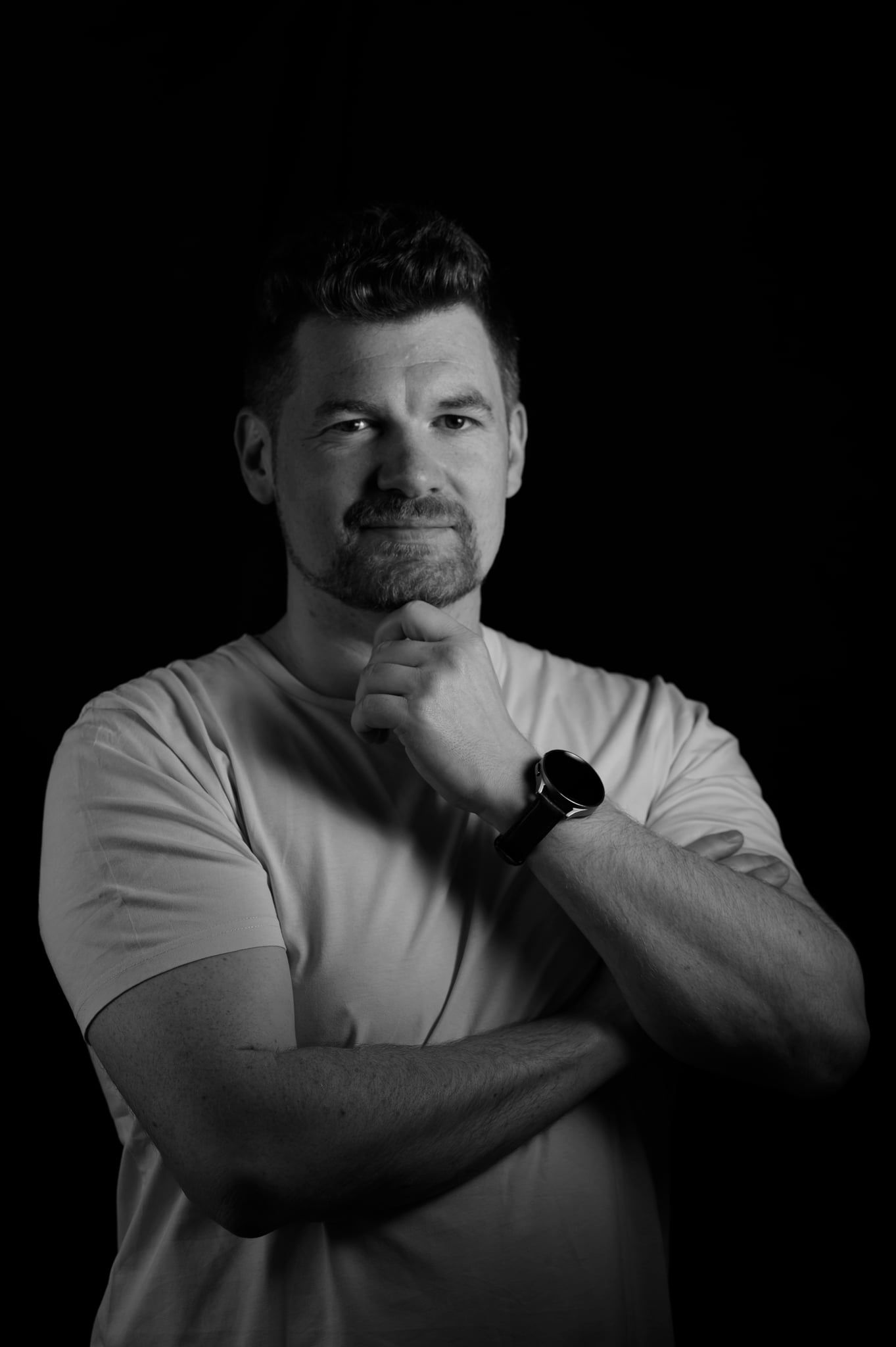 Daniel im Low-Key-Licht in dynamischer Haltung mit der Hand am Kinn