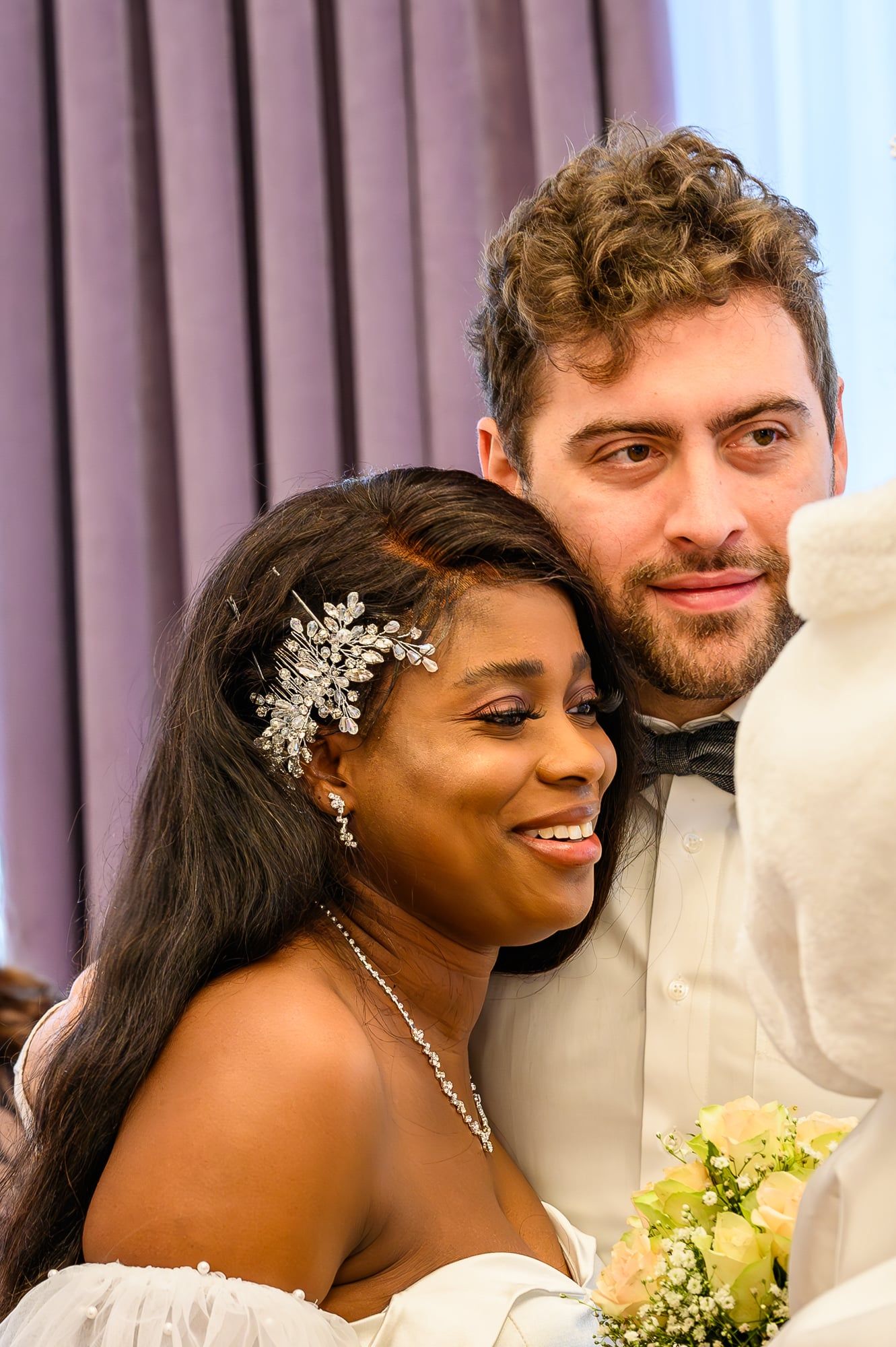 Brautpaar lächelt eng aneinandergeschmiegt, die Braut mit funkelndem Haarschmuck – Hochzeit in Augsburg