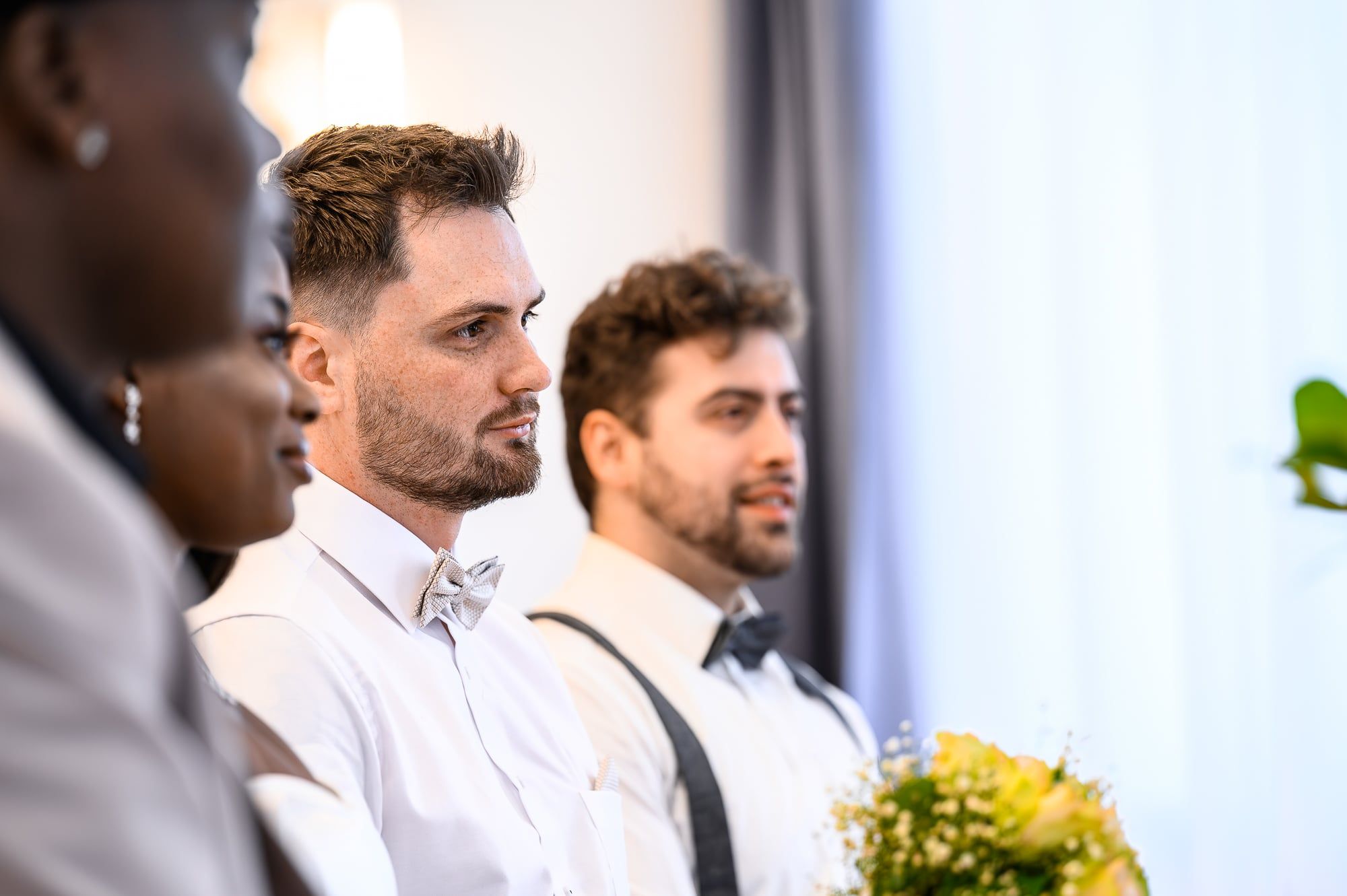 Bräutigam und Trauzeuge sitzen nebeneinander und verfolgen die Trauung – Hochzeit in Augsburg