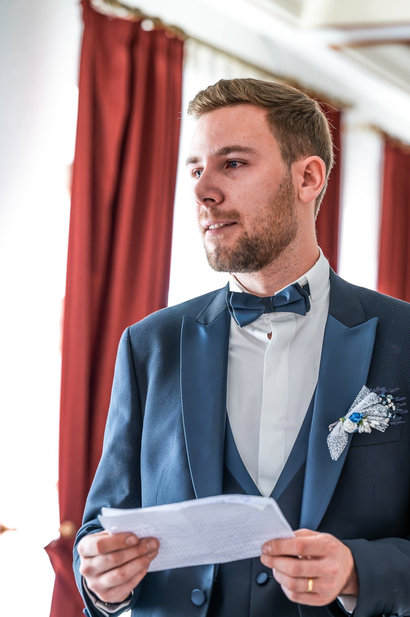 Bräutigam im blauen Anzug liest sein Eheversprechen von einem Blatt vor – Hochzeit in Wittislingen