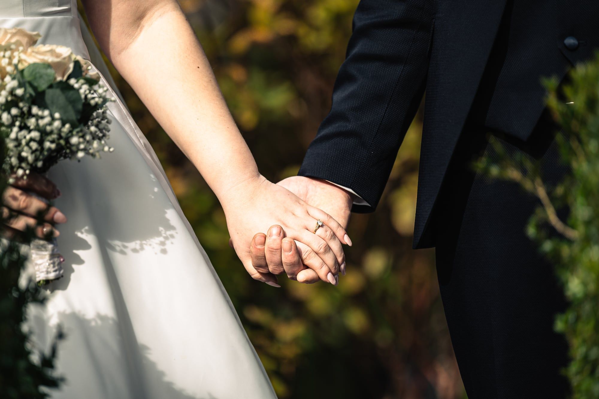 Brautpaar hält sich an den Händen, die Braut mit Strauß, Detailaufnahme – Hochzeit in Wittislingen