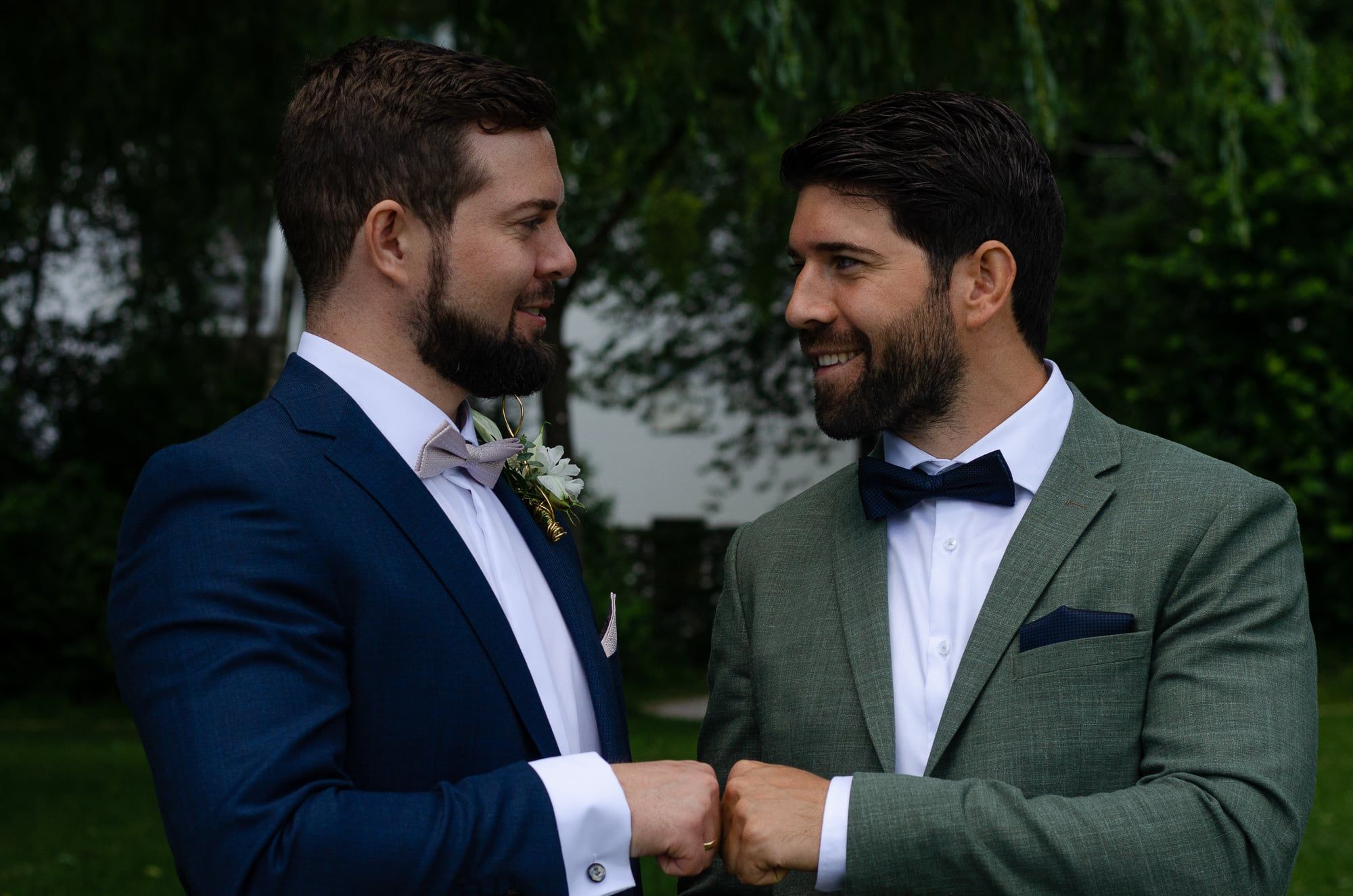 Bräutigam und Trauzeuge stoßen in Anzügen mit den Fäusten an – Hochzeit in Augsburg