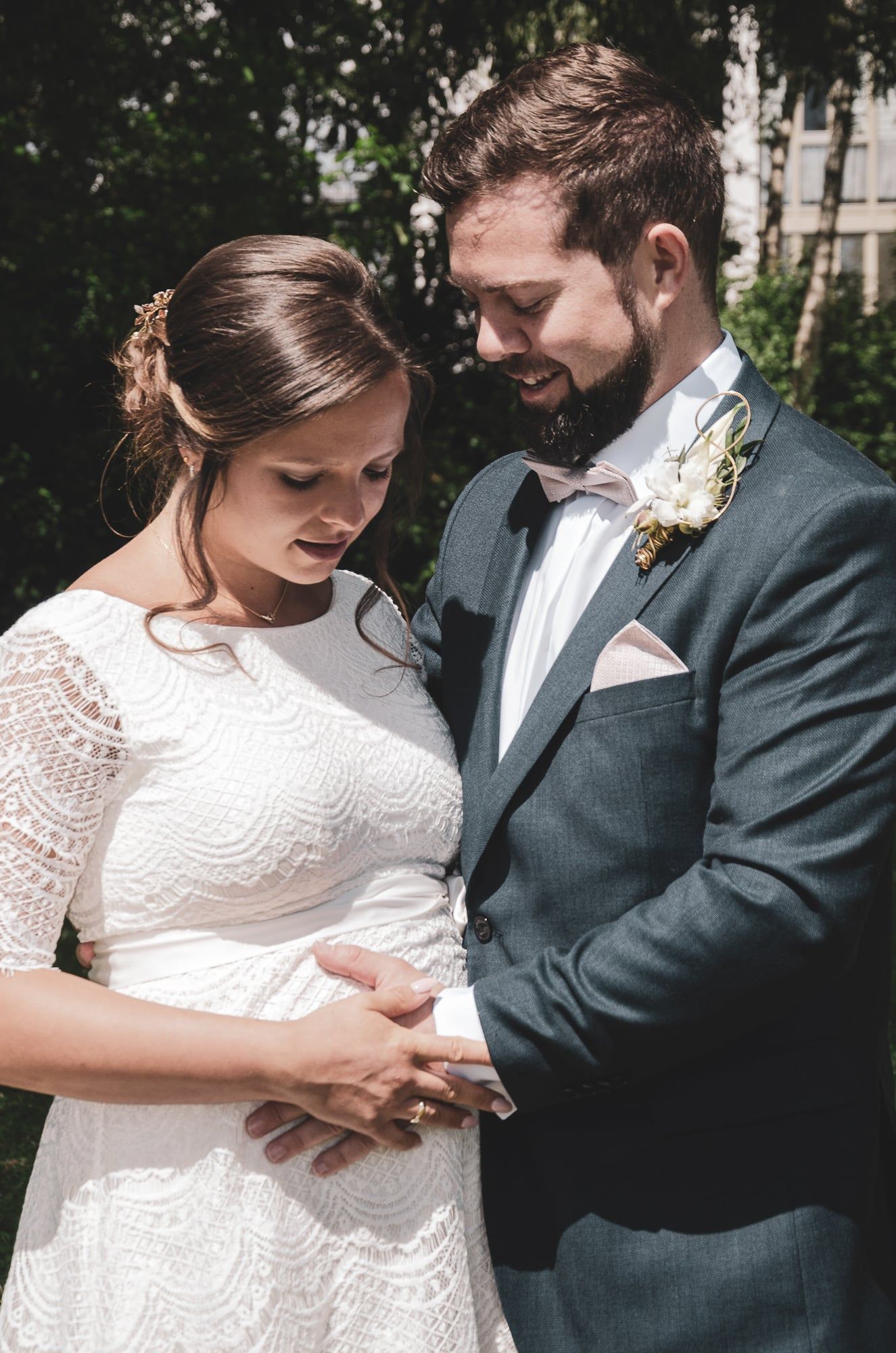 Bräutigam hält die Braut im Arm, beide blicken lächelnd nach unten – Hochzeit in Augsburg