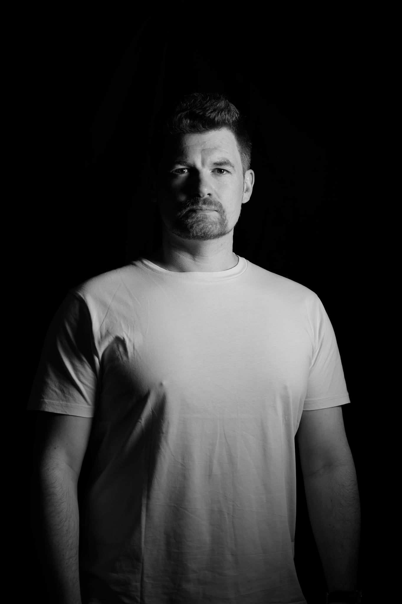 Low-Key-Portrait von Daniel mit einer Lichtquelle, harte Schatten auf Gesicht und Oberkörper