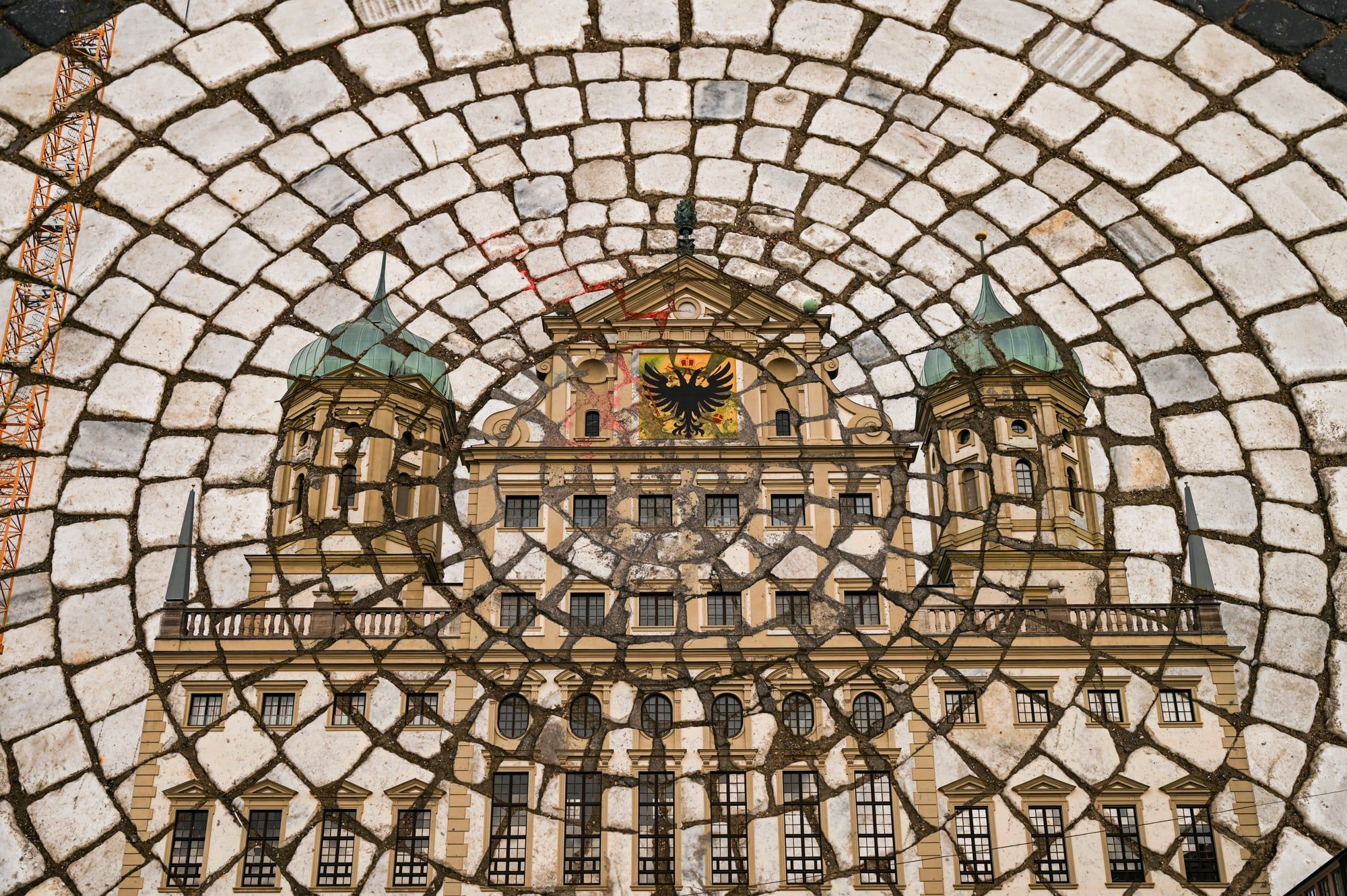 Mehrfachbelichtung: das Augsburger Rathaus in einem Bogen aus Pflastersteinen